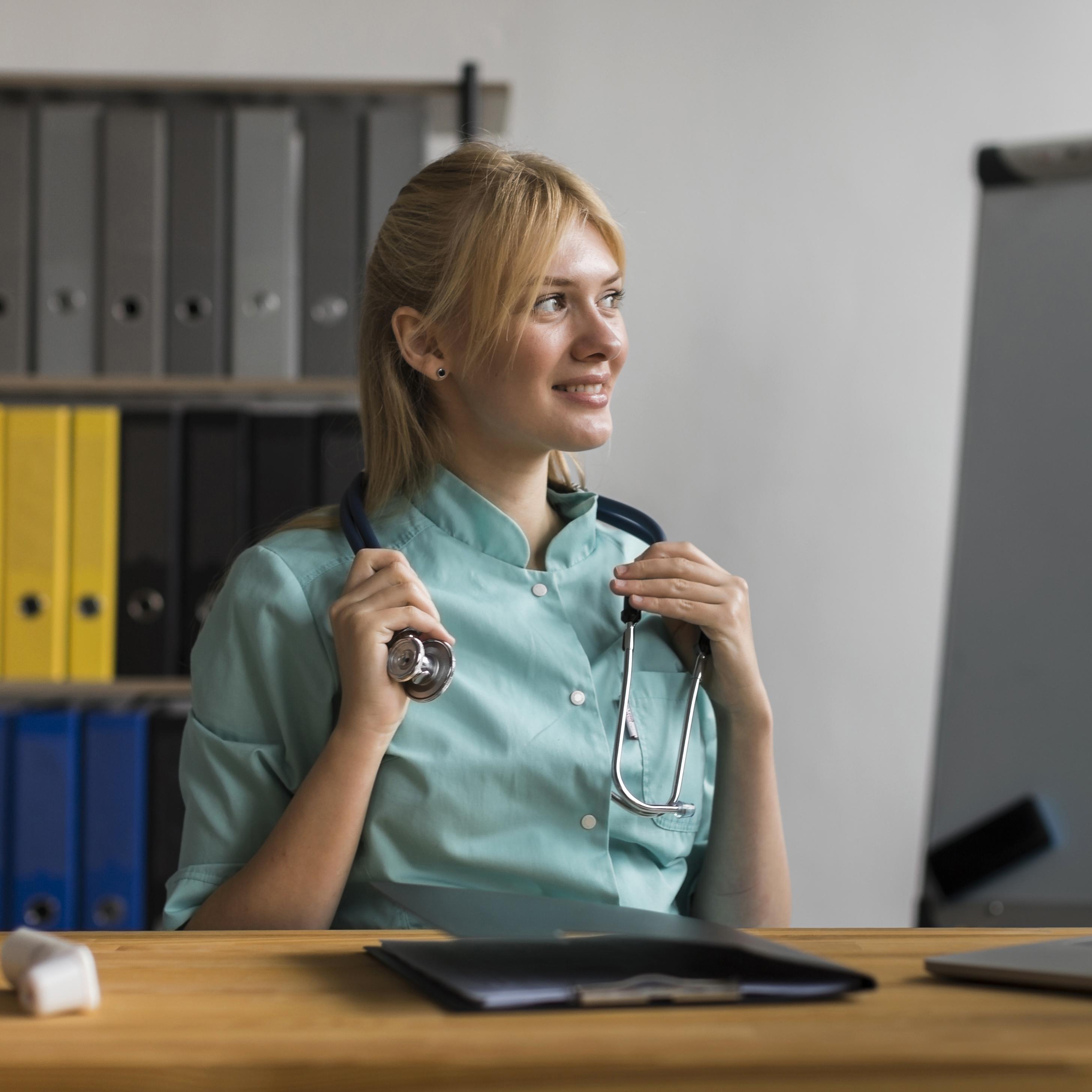 smiley female nurse office with laptop